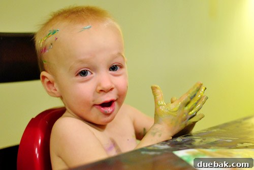Clara, the toddler artist, smiling after her pumpkin painting session