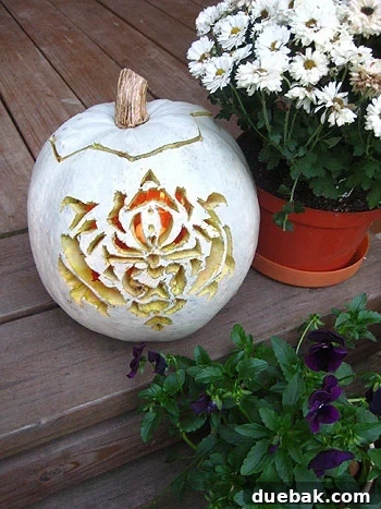 Carved pumpkin with an intricate pattern and another with a monogram