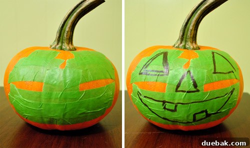 Middle-sized pumpkin with painter's tape forming a jack-o-lantern face
