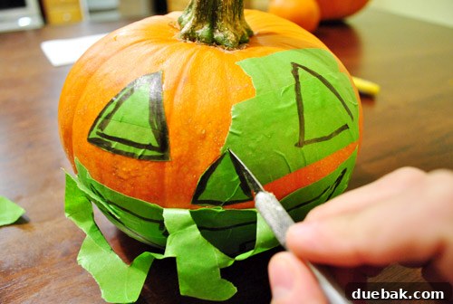 Middle pumpkin with the jack-o-lantern tape stencil complete, ready for paint
