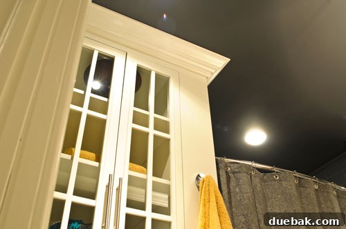 Graphite Gray Bathroom Renovation 4 Custom built-in storage units flanking a stylish vanity, featuring a DIY striped shower curtain in a modern gray bathroom.