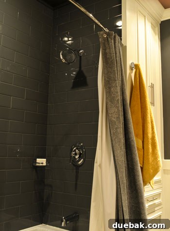 Graphite Gray Bathroom Renovation 6 High-gloss gray subway tiles in a modern bathroom, reflecting light and creating a chic, spacious feel.