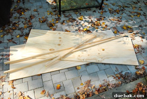 DIY Built-In Refrigerator Installation 4 Plywood sheets and pine trim pieces laid out, ready for cutting and assembly