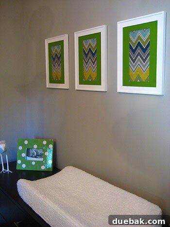 Nursery with a DIY white spray-painted chandelier and framed fabric scrap artwork