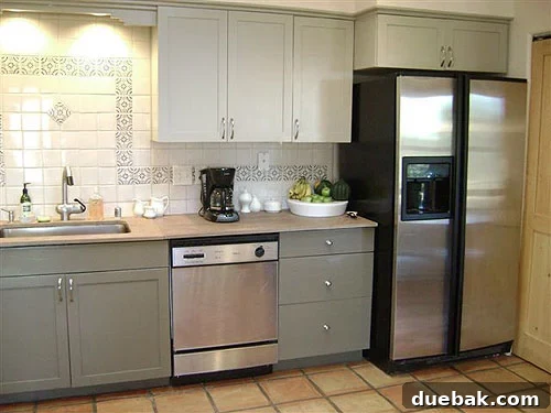 painted-kitchen-cabinet-makeover-before-and-after Beautifully repainted kitchen cabinets with a two-tone color scheme, highlighting a budget-friendly and successful DIY kitchen renovation. Displaying cherished creamware items.