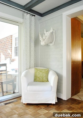 The Zero Three Directive 8 Large white Cardboard Safari rhino trophy, Robbie, displayed prominently in a cozy corner of the room
