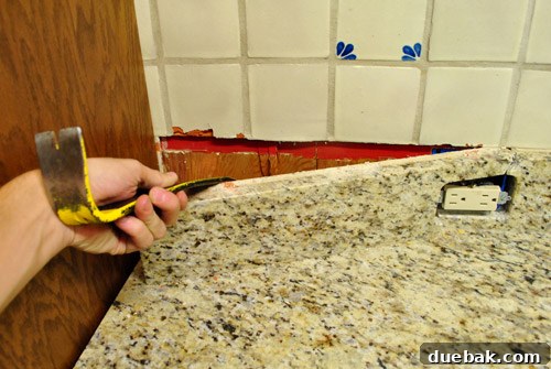 Removing backsplash with crowbar