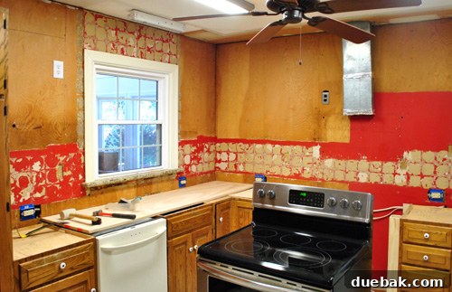 Kitchen wall after backsplash tile removal, showing adhesive residue