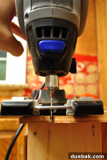 Man using a Dremel Trio to cut plywood on a kitchen wall