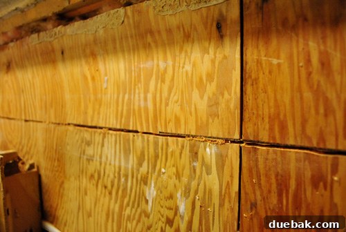 Close-up of a straight cut made in plywood on kitchen wall