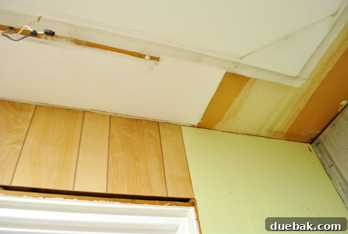Close up of unsightly unpainted paneling and ceiling in kitchen