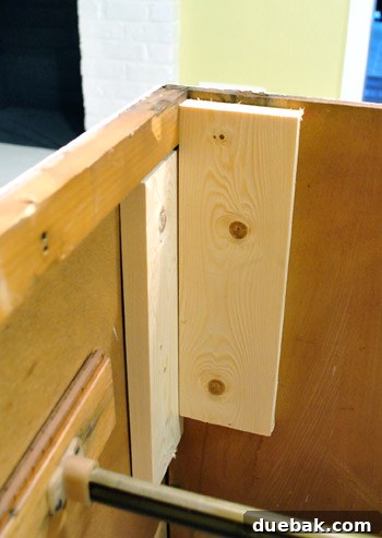 Marking and installing scrap wood inside kitchen cabinet