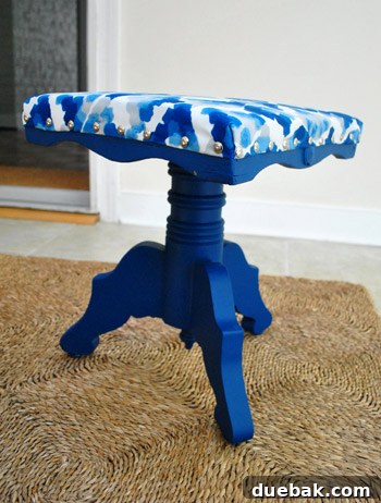 Side view of the newly upholstered navy stool