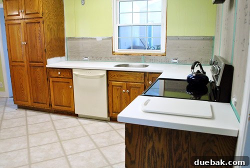 Elegant white Corian countertops extending into a spacious kitchen design, emphasizing cleanliness and modern style.
