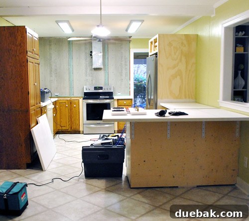 During installation of Corian countertops, showing the temporary state of the kitchen with tools and materials.