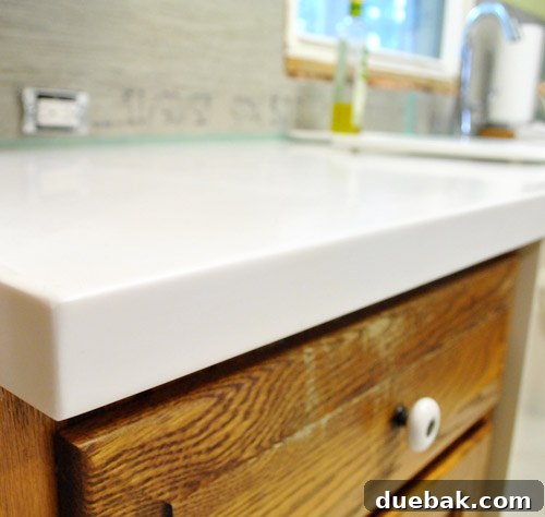 Old kitchen cabinets looking dated against the new, sleek white Corian countertops, highlighting the next renovation phase.