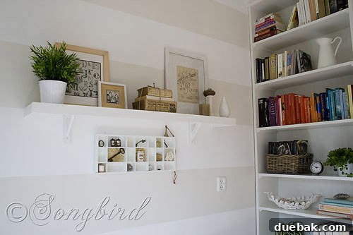 A tastefully arranged small desk area, featuring a potted plant, a framed picture, and a unique key displayed against a map.