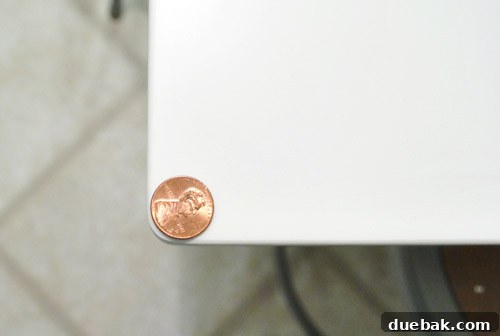 A close-up view of the rounded corner of the kitchen peninsula, with a penny placed on the edge for scale.