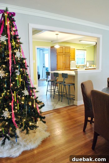 A wider view of the kitchen space, showing the existing orange-toned wooden cabinets alongside the new peninsula.