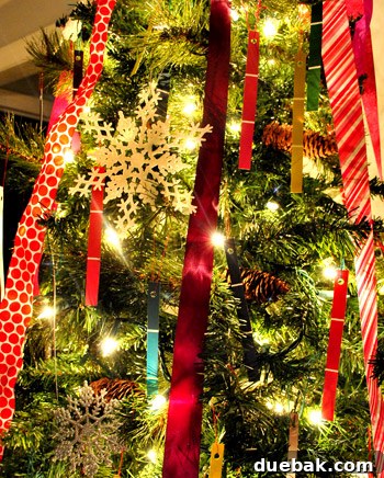 Finished paint chip ornaments hanging on Christmas tree branches.