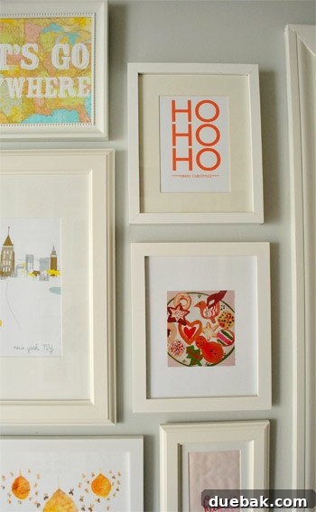 Framed 'Ho Ho Ho, Merry Christmas' print, holiday cookies illustration from Woman's Day magazine, and silver ornaments with wrapping paper background.