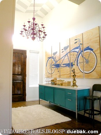 Bright and colorful entryway after makeover, featuring a bicycle art and teal credenza