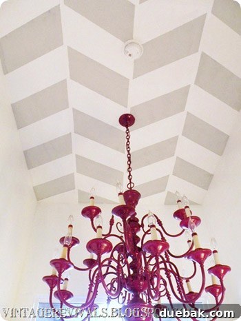 Herringbone patterned ceiling with a vibrant purple chandelier