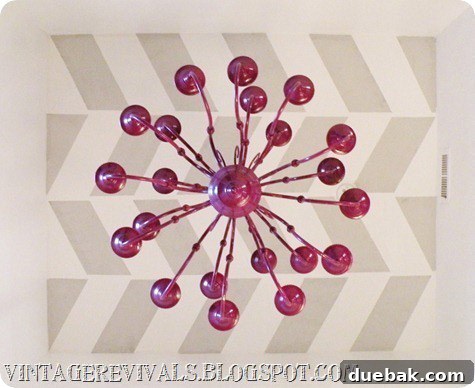 Close-up of the purple chandelier 'Octy' hanging from the herringbone ceiling