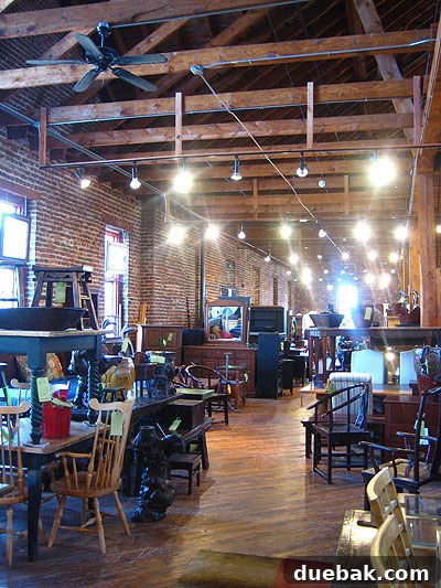 Interior view of a Green Front Furniture warehouse, showcasing rows of furniture