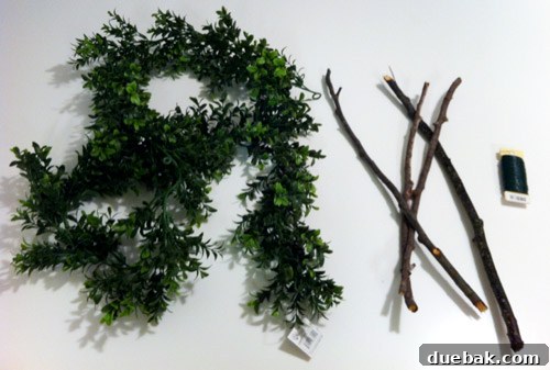 Our Dazzling Outdoor Christmas Display 16 Materials used for the DIY square wreath: four sticks of equal length, a faux boxwood garland, and green floral wire.
