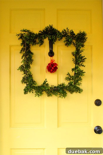 Our Dazzling Outdoor Christmas Display 18 The finished DIY square wreath with a red kissing ball hanging on the front door, resting on the door knocker.