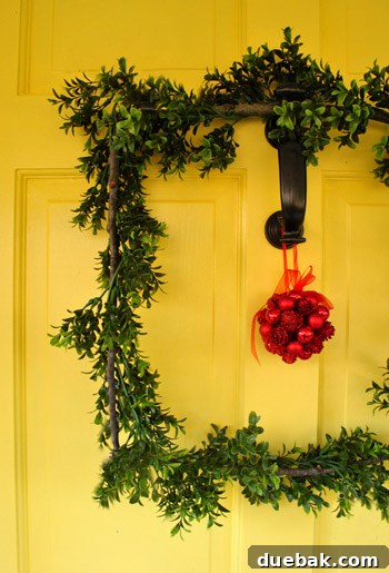 Our Dazzling Outdoor Christmas Display 19 A heartwarming shot of the DIY 'Charlie' wreath with the red kissing ball, showcasing its charmingly rustic and unique square design.
