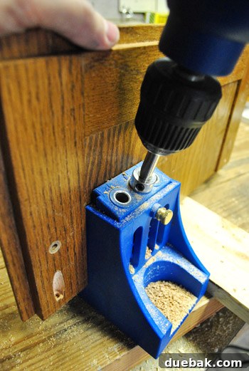 Kreg jig in use, creating pocket holes for joining cabinet door sections.