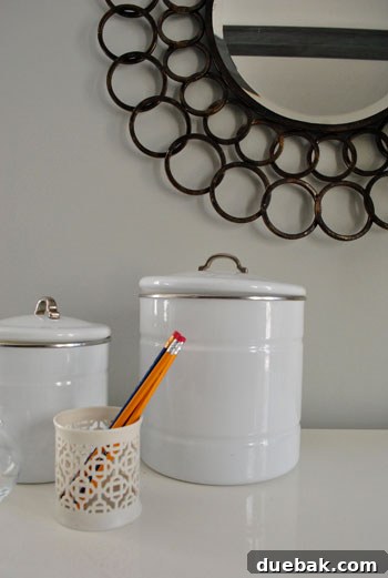 A stylish round mirror hanging above a desk in a living room, contributing to a balanced and elegant decor.