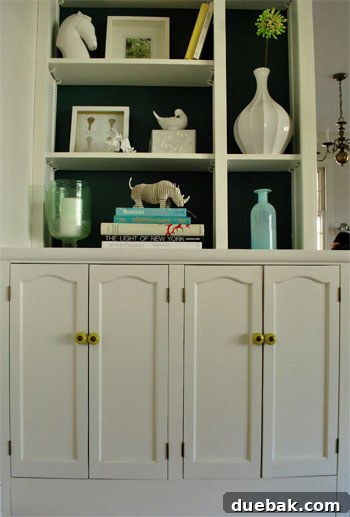 Close-up of new, cheerful greeny-yellow knobs installed on a dining room built-in cabinet, showcasing a bright update.