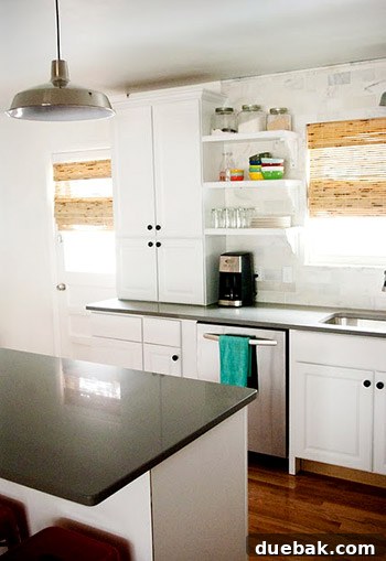 Completed kitchen with new appliances, lighting, and red counter stools
