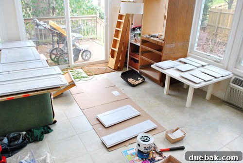 Freshly primed kitchen cabinets showing initial progress in home renovation