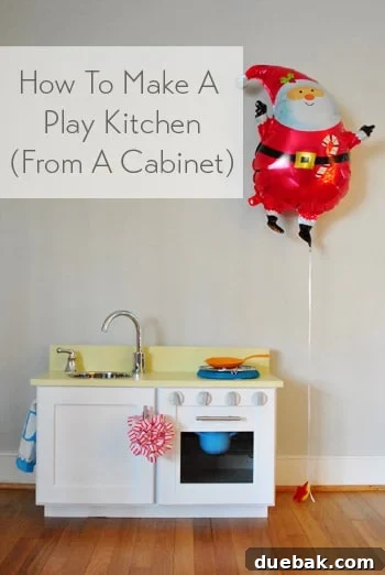 Homemade play kitchen built from an upcycled cabinet, showing the finished product with sink and oven