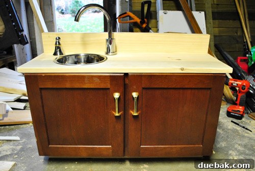 Play kitchen counter securely attached to the cabinet