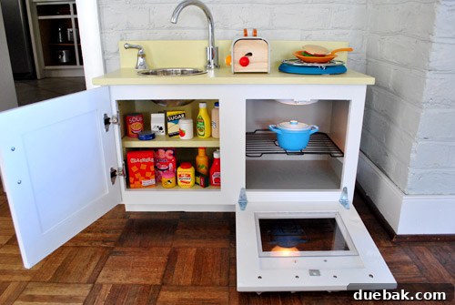 Close-up of painted play kitchen interior, showing oven and pantry