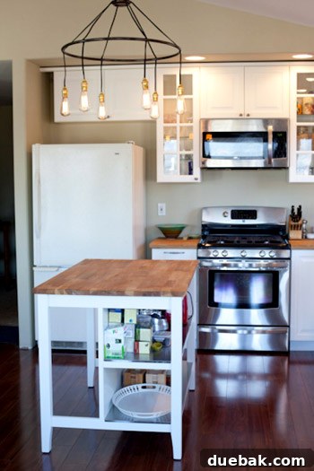 Close-up of the new kitchen island, showcasing the elegant chandelier and finishes