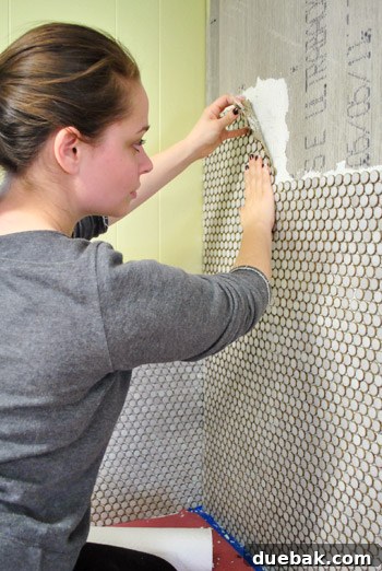 The progress of tiling the large back wall of the kitchen with penny tiles