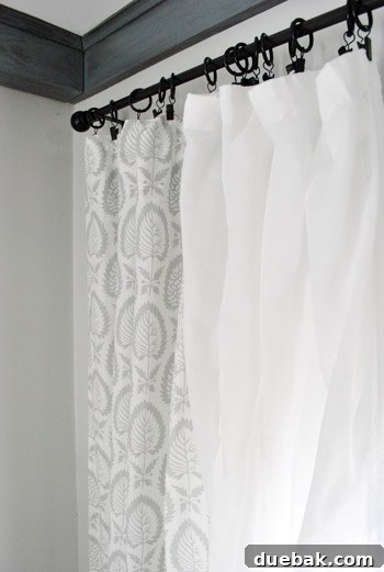 Repurposing Curtain Panels 6 Beautifully layered patterned and sheer curtains hanging on a curtain rod, showcasing seamless integration.