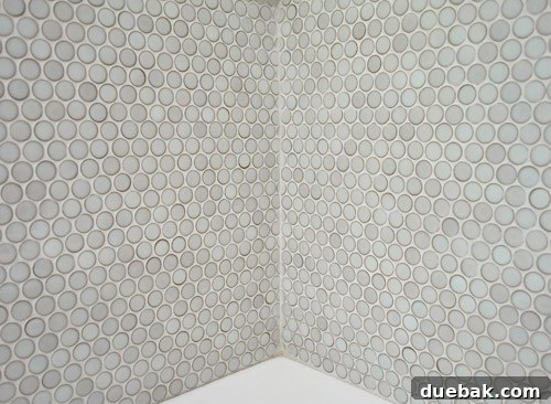 Caulked corner seam of penny tiles matching the grout color, showing a professional finish.