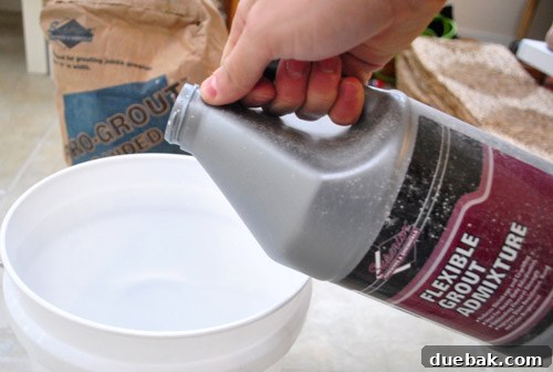 Close-up of grout being mixed to a toothpaste-like consistency.