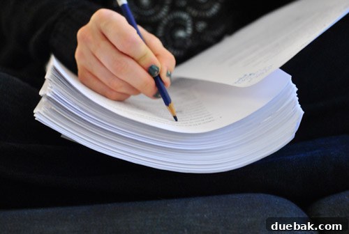 Close-up of manuscript pages with handwritten notes and edits in blue pencil.
