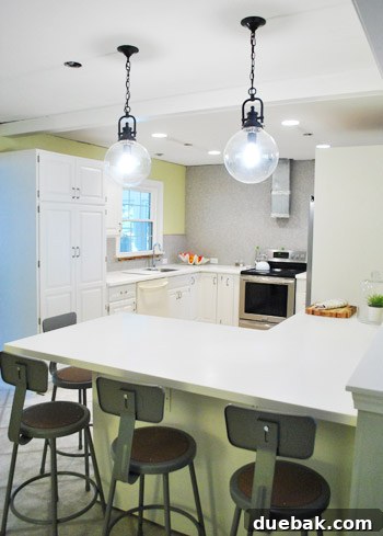 Elevating Kitchen Style with Twin Glass Pendants 5 Another tall shot of the kitchen peninsula, showing more of the wall and cabinet
