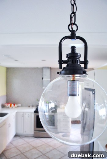 Elevating Kitchen Style with Twin Glass Pendants 10 A closer view of the kitchen peninsula, showcasing the pendant lights and countertop