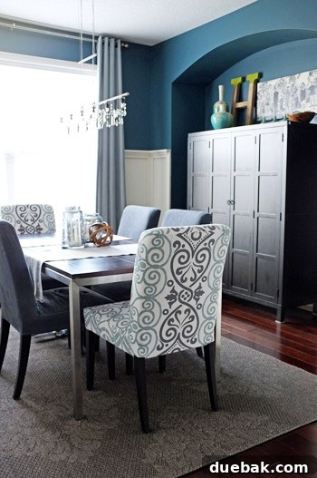 Detailed view of a side dining chair, impeccably dyed to a rich teal color that perfectly matches the room's Plumage walls. This image highlights the success of the dyeing process and the chair's cohesive integration into the overall design.