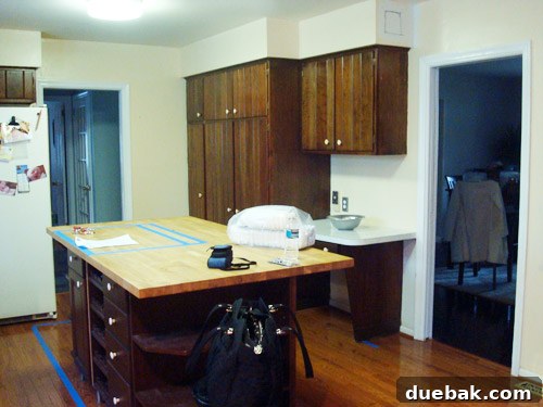 Interior view of original house walls from a different angle before demolition, showcasing outdated decor